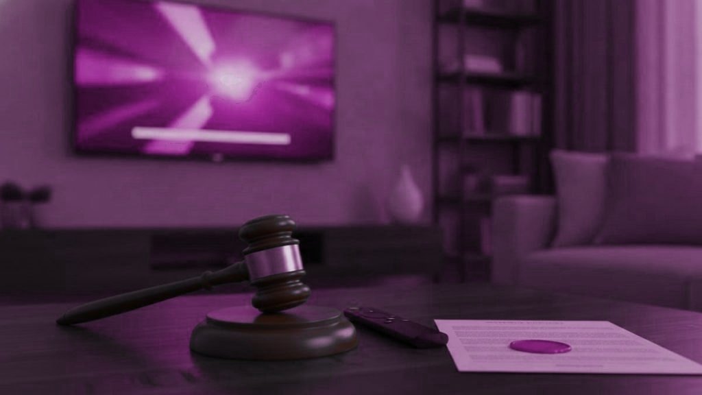 A judge gavel, a streaming remote and a sealed document on a coffee table in front of a TV