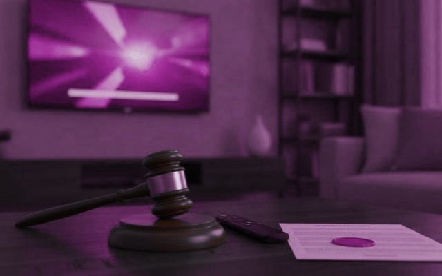 A judge gavel, a streaming remote and a sealed document on a coffee table in front of a TV